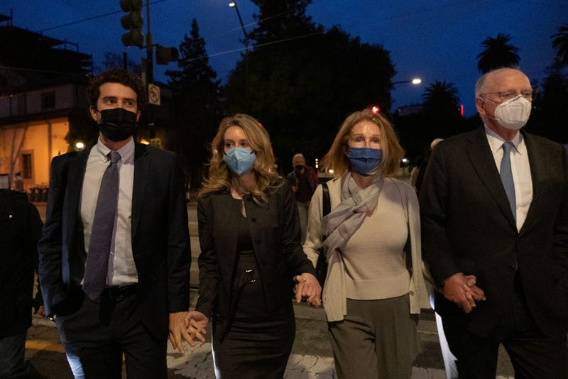 Theranos founder and former CEO Elizabeth Holmes (2nd L) walks with her partner Billy Evans (L), her mother Noel Holmes and a lawyer as they leave the Robert F. Peckham Federal Building on January 3, 2022 in San Jose, California.