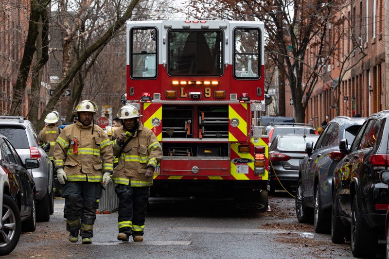 Firefighters are pictured near the scene of the fatal fire in the Fairmount neighborhood that killed 13 people, including seven children, on Jan. 5, 2022.