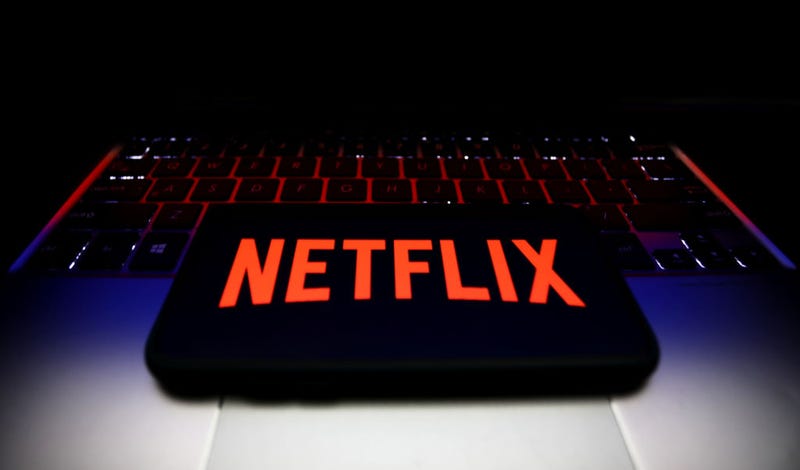 Netflix logo displayed on a phone screen and a laptop keyboard