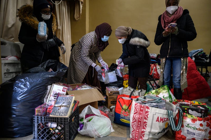 Volunteers prepare donations of clothes, food, and other items for people displaced by a fire at an apartment building nearby in the Bronx, New York on January 10, 2022