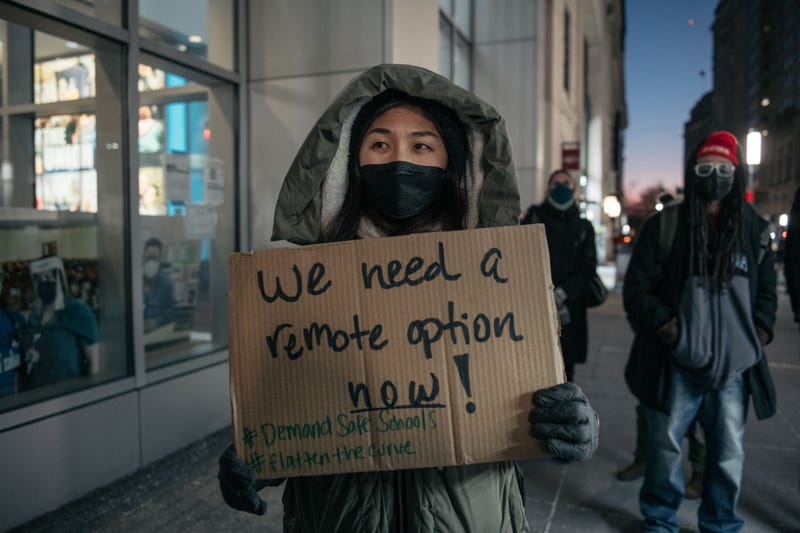 A New York City public school teacher holds a sign at a rally demanding increased COVID-19 safety measures and a remote learning option on January 10, 2022 in New York City.