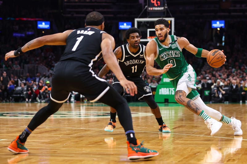 Jayson Tatum drives past Kyrie Irving and Bruce Brown