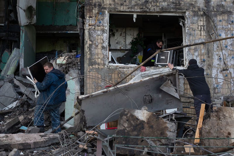 People remove the rubble as a result of shelling in the residential area on March 14, 2022 in Obolon district of Kyiv, Ukraine. Russian forces continue to attempt to encircle the Ukrainian capital, although they have faced stiff resistance and logistical challenges since launching a large-scale invasion of Ukraine last month. Russian troops are advancing from the northwest and northeast of the city.
