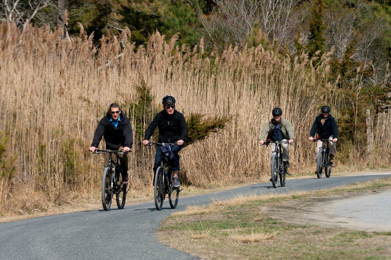 US President Joe Biden (C) rides his bike through Cape Henlopen State Park in Rehoboth Beach, Delaware, on March 20, 2022. 
