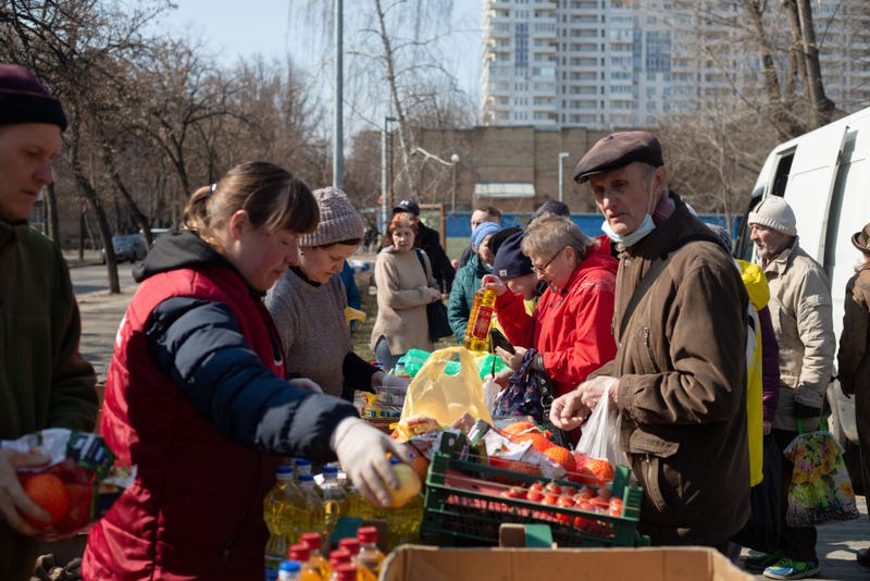 People buy groceries at the lot in the street on March 24, 2022 in Kyiv, Ukraine. Although few nights pass without shellfire or air strikes in some part of the capital, the advance of Russian ground forces here has largely stalled and, in some cases, has been repelled. (Photo by Anastasia Vlasova/Getty Images)