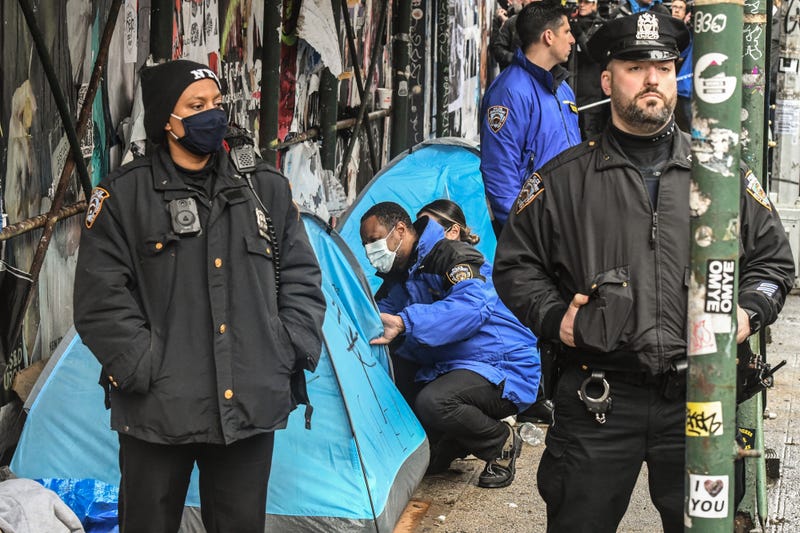 Members of the NYPD work with the Department of Sanitation to clear a homeless encampment near Tompkins Square Park in the East Village on April 6, 2022