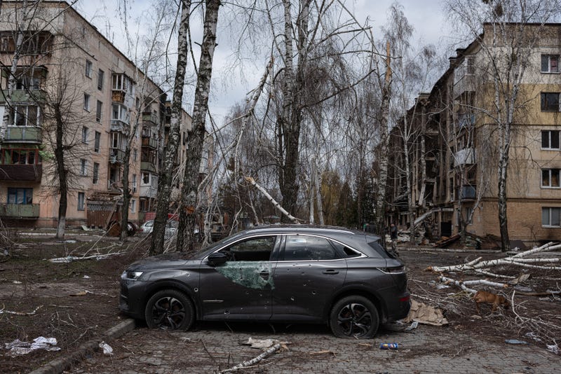 A damaged car is seen next to a heavily damaged apartment building on April 6, 2022 in Hostomel, Ukraine