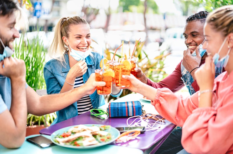 Friends having drinks while wearing masks amid the COVID-19 pandemic