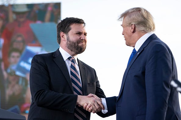 (L-R) J.D. Vance, a Republican candidate for U.S. Senate in Ohio, shakes hands with former President Donald Trump during a rally hosted by the former president at the Delaware County Fairgrounds on April 23, 2022 in Delaware, Ohio. 