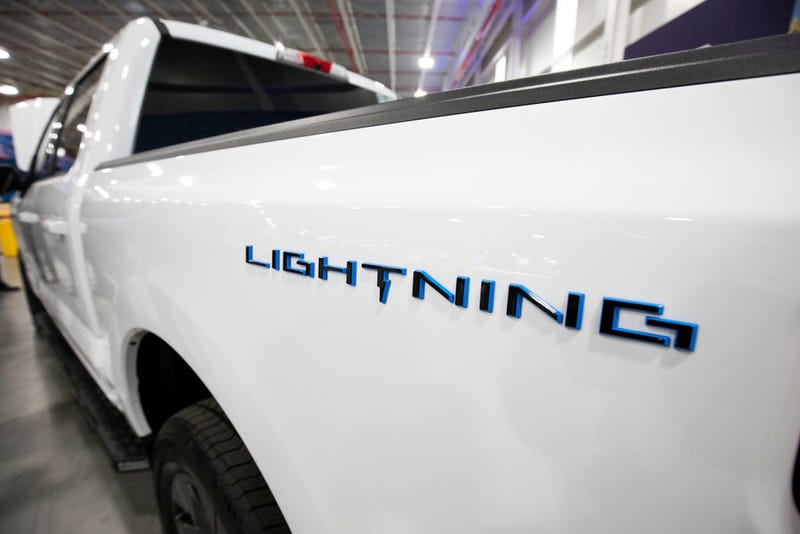 A white Ford F-150 Lightning pickup truck is shown