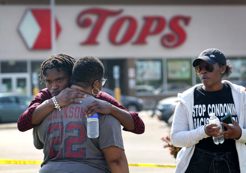 People gathered outside of Tops market embrace on May 15, 2022 in Buffalo, New York. Yesterday a gunman opened fire at the store, killing ten people and wounding another three. Suspect Payton Gendron was taken into custody and charged with first degree murder. U.S. Attorney Merrick Garland released a statement, saying the US Department of Justice is investigating the shooting "as a hate crime and an act of racially-motivated violent extremism."