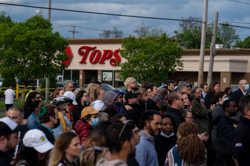 People attend a vigil across the street from Tops Friendly Market at Jefferson Avenue and Riley Street on Tuesday, May 17, 2022 in Buffalo, NY. The Supermarket was the site of a fatal shooting of 10 people at a grocery store in a historically Black neighborhood of Buffalo by a young white gunman is being investigated as a hate crime and an act of racially motivated violent extremism, according to federal officials.