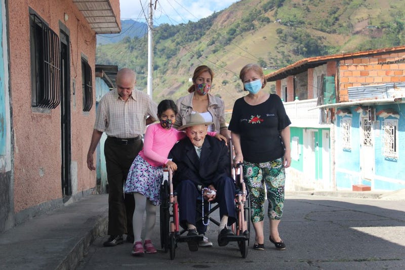 Juan Vicente Mora poses for a photograph with his family in the streets of the town where he currently lives. San José de Bolivar, January 24, 2022