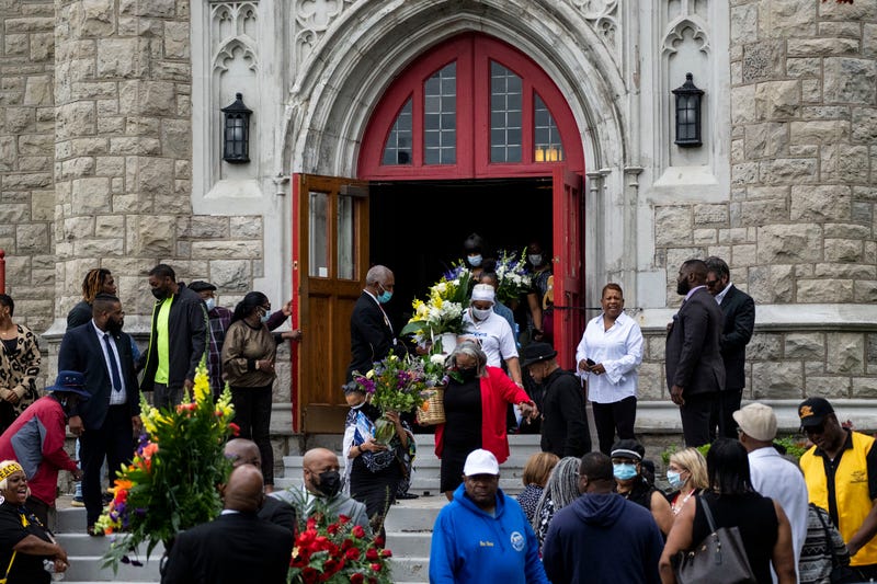 Mourners carry out flowers as people depart from the funeral of Heyward Patterson at Lincoln Memorial United Methodist Church on Friday, May 20, 2022 in Buffalo, NY. The Patterson was one of 10 people who were killed in the mass shooting at Tops Friendly Market at Jefferson Avenue and Riley Street in a historically Black neighborhood of Buffalo by a young white gunman is being investigated as a hate crime and an act of racially motivated violent extremism, according to federal officials.