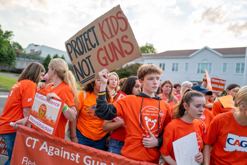 Teenagers hold up signs during a rally for National Gun Violence Awareness Day on June 03, 2022 in Newtown, Connecticut.