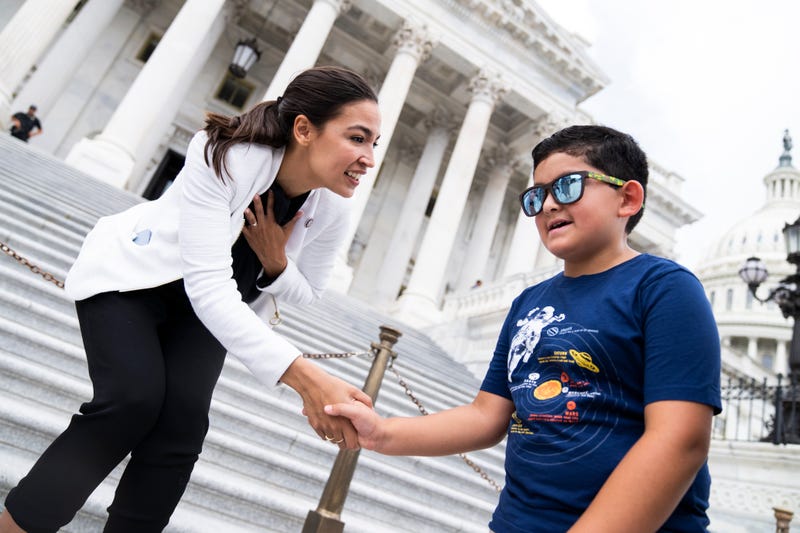 Rep. Alexandria Ocasio-Cortez, D-N.Y., greet Mariano, 8, on the House steps of the U.S. Capitol during the last votes of the week on Thursday, June 16, 2022