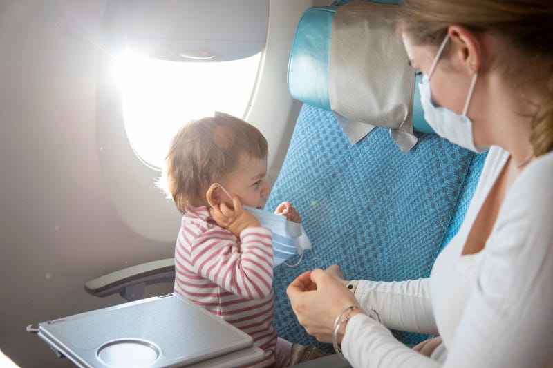 Baby with mask on plane stock photo
