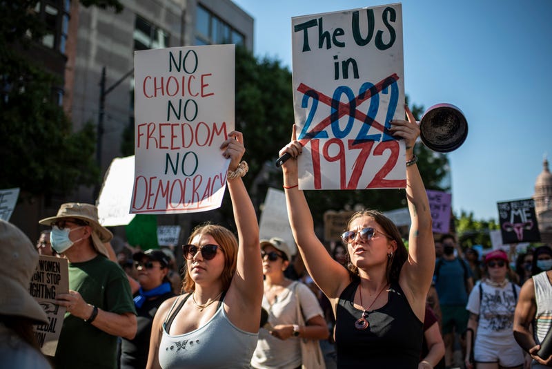 Protesters march while holding signs during an abortion-rights rally on June 25, 2022 in Austin, Texas.