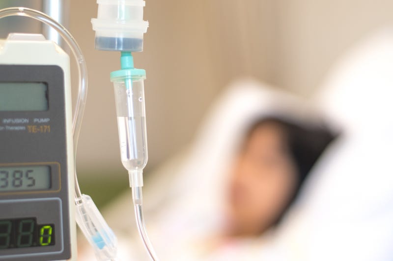 Child patient with IV line in hand sleep on hospital bed.