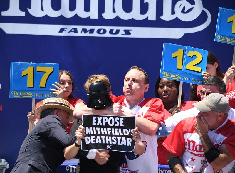 Two protesters interrupt the Nathan's Famous International Hot Dog Eating Contest in which competitive eater Joey Chestnut wins his 15th title eating 63 Nathan's hot dogs on July 4, 2022, in Coney Island