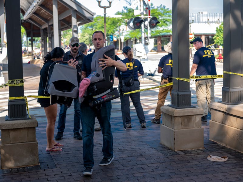 People gather their children's car seats and belongings from the scene of a shooting at a Fourth of July parade on July 5, 2022 in Highland Park, Illinois.