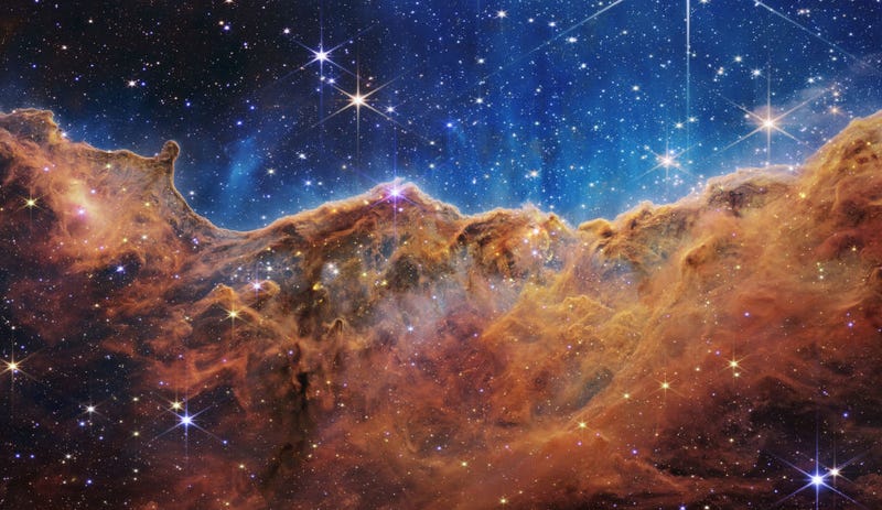In this handout photo provided by NASA, a landscape of mountains and valleys speckled with glittering stars is actually the edge of a nearby, young, star-forming region called NGC 3324 in the Carina Nebula, on July 12, 2022 in space. Captured in infrared light by NASA's new James Webb Space Telescope, this image reveals for the first time previously invisible areas of star birth. (Photo by NASA, ESA, CSA, and STScI via Getty Images)