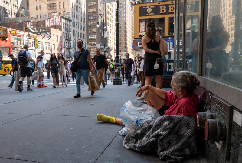 A woman rests on a Manhattan street during a heat wave on July 22, 2022 in New York City.