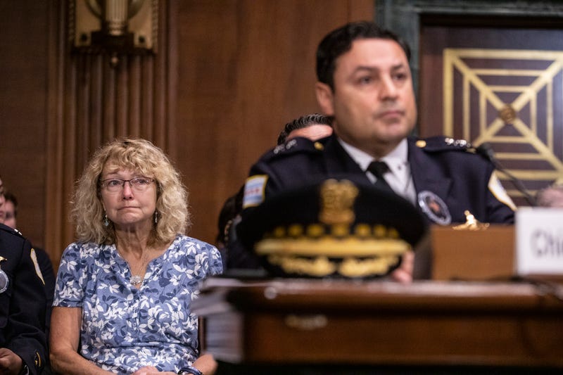 A woman listens to testimony from police officers during a U.S. Senate hearing.