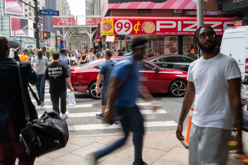 People walk by a 99-cent pizza store in Manhattan on July 28, 2022 in New York City. 