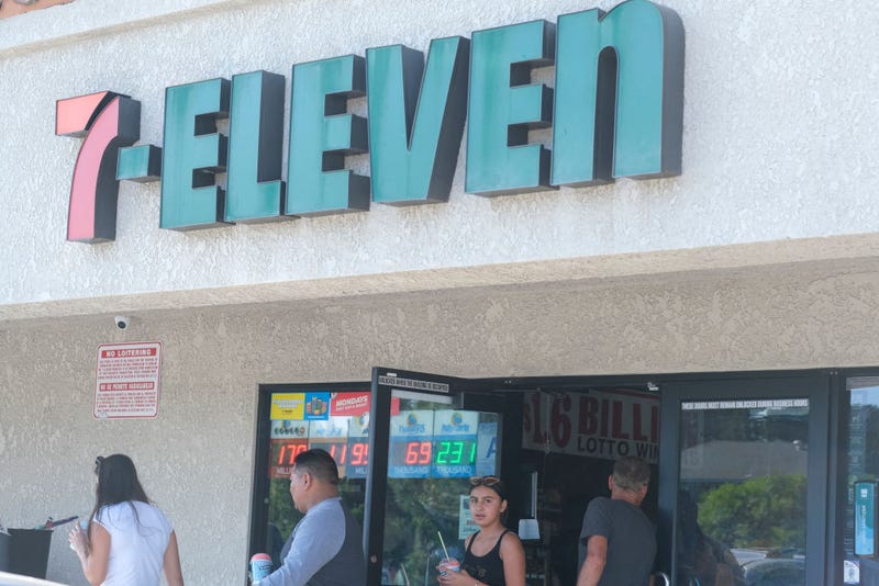 People leave a 7-Eleven convenience store.
