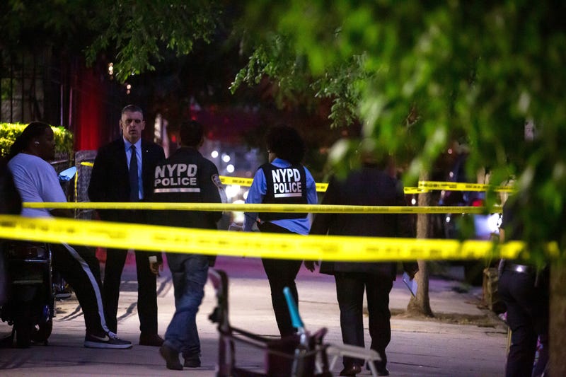 NYPD officers investigate the scene of a shooting in the Crown Heights neighborhood in Brooklyn on July 21, 2022