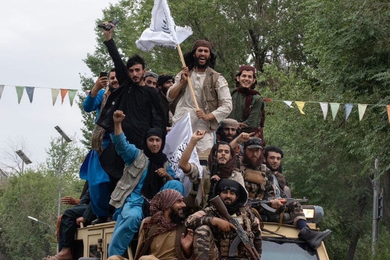 Men ride on top of an armored vehicle during a celebration of the first anniversary of the Taliban's return to power on August 15, 2022 in Kabul, Afghanistan.