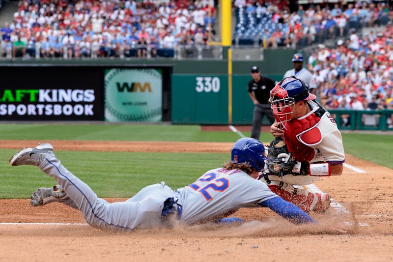 Brett Baty, #22 of the New York Mets, slides safely into home plate ahead of the tag by catcher J.T. Realmuto, #10 of the Philadelphia Phillies, on a two-run single by Michael Perez #35 in the second inning of a game at Citizens Bank Park on Aug. 21, 2022, in Philadelphia, Pennsylvania.