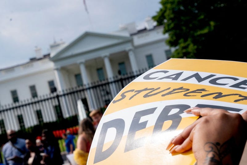 An activist holds a "cancel student debt" sign as they gather to rally in front of the White House in Washington, D.C., on Aug. 25, 2022. 