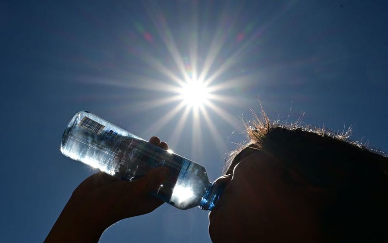 A child sips water from a bottle under a scorching sun on August 30, 2022, in Los Angeles.