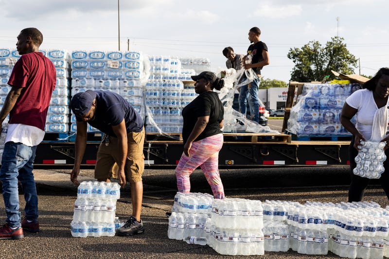 JACKSON, MS - AUGUST 31: Cases of bottled water are handed out at a Mississippi Rapid Response Coalition distribution site on August 31, 2022 in Jackson, Mississippi. Jackson is experiencing a third day without reliable water service after river flooding caused the main treatment facility to fail. Late Tuesday night, President Joe Biden declared an emergency amid the crisis. (Photo by Brad Vest/Getty Images)