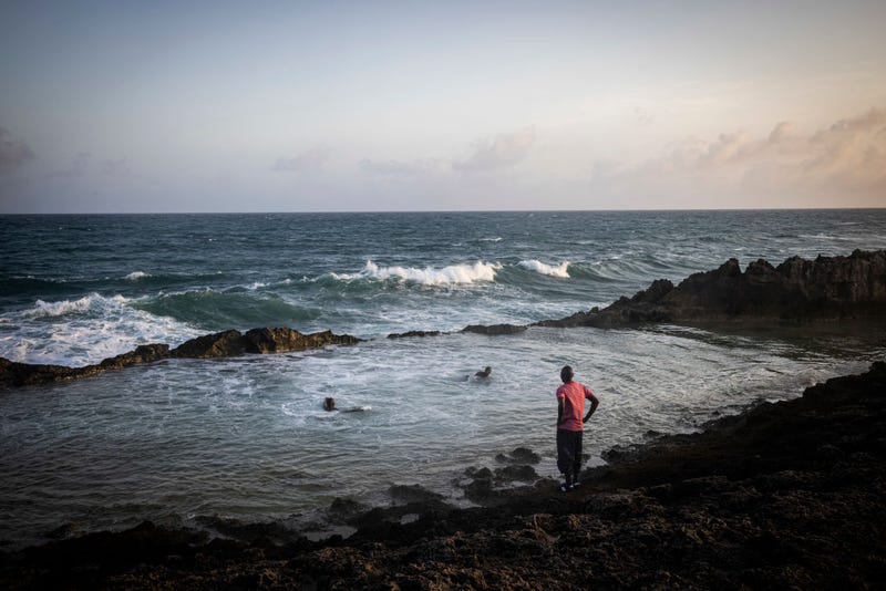 People relax and swim on a secured beach area near the runway of Aden Adde International Airport at sun set on September 4, 2022 in Mogadishu, Somalia. es
