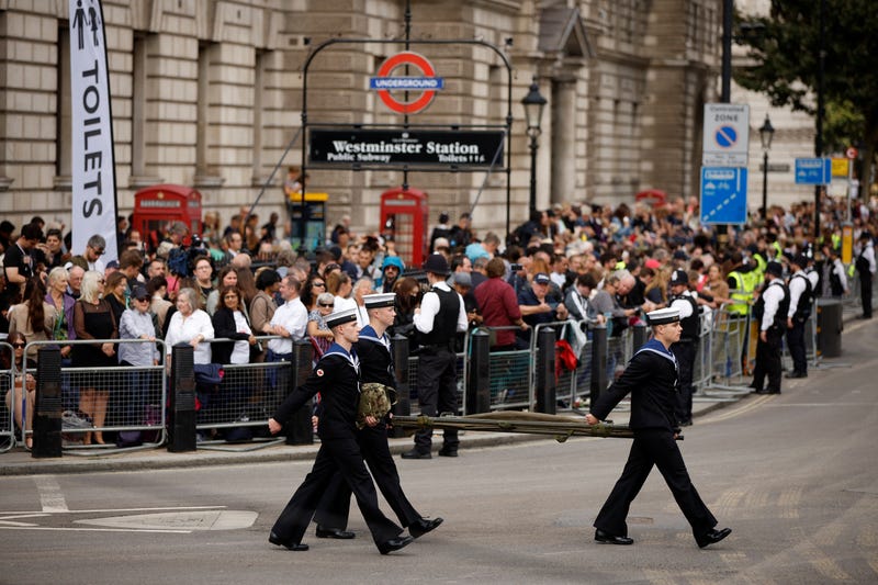 Members of the public wait to see the coffin of Queen Elizabeth II as it is transported from Buckingham Palace to the Palace of Westminster on September 14, 2022 in London