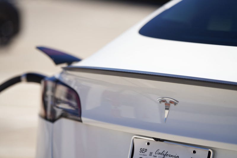 A Tesla vehicle is plugged into a Tesla charging station in a parking lot on September 22, 2022 in Santa Monica, California.
