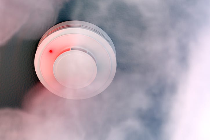 Mounted smoke detector in a smoke filled room.
