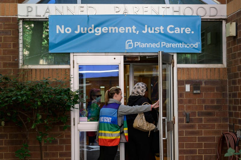 A clinic escort assists a patient at a Planned Parenthood Health Center in Philadelphia.