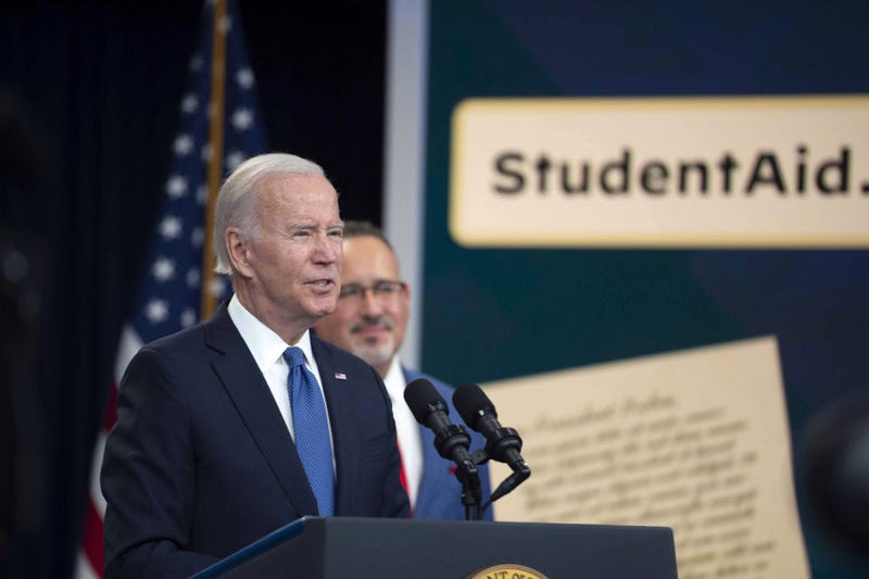 Biden speaks as Miguel Cardona, US secretary of education, right, listens in the Eisenhower Executive Office Building in Washington, on Monday, Oct. 17, 2022. Biden said eight million borrowers applied for the student debt relief program during a beta test to receive up to $20,000 in debt cancellation and that the official website is up and available for use.