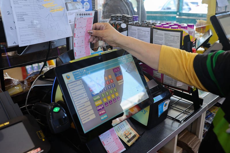 A cashier insert Powerball lottery tickets to the machine for a costumer at a 7-Eleven store in Milpitas, California, United States on November 7, 2022.