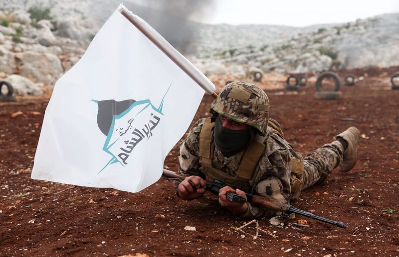 A fighter affiliated with Syria's "Hayat Tahrir al-Sham" (HTS) rebel-group, takes part in a military excercise on attacking tactics with live ammunition, on the outskirts of the northwestern province of Idlib, on November 8, 2022. - The last pocket of armed opposition to Syrian President Bashar al-Assad's regime includes large swathes of Idlib province and parts of the neighbouring Aleppo, Hama and Latakia provinces. Hayat Tahrir al-Sham (HTS), headed by ex-members of Syria's former Al-Qaeda franchise, is the dominant group in the area but other rebel groups are also active.