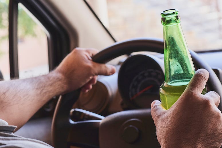 Man holding beer while driving