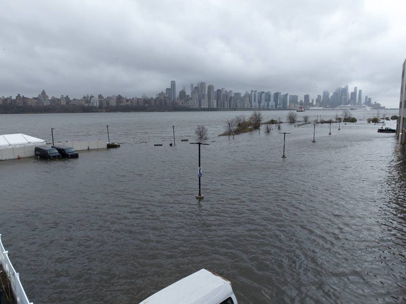 Storm clouds are seen as the Hudson River spills over a river wall in front of the skyline of lower Manhattan in New York City during an severe flooding due to the winter storm in New Jersey on Dec. 23, 2022