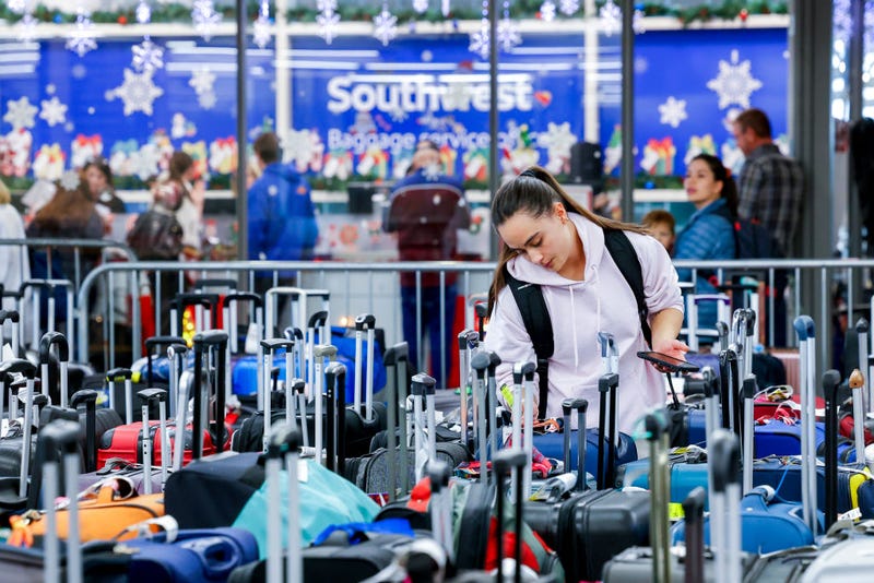 Pristine Floyde searches for a suitcase in a baggage holding area for Southwest Airlines on December 28, 2022 in Denver, Colorado. More than 15,000 flights were canceled since winter weather began impacting air travel on December 22.