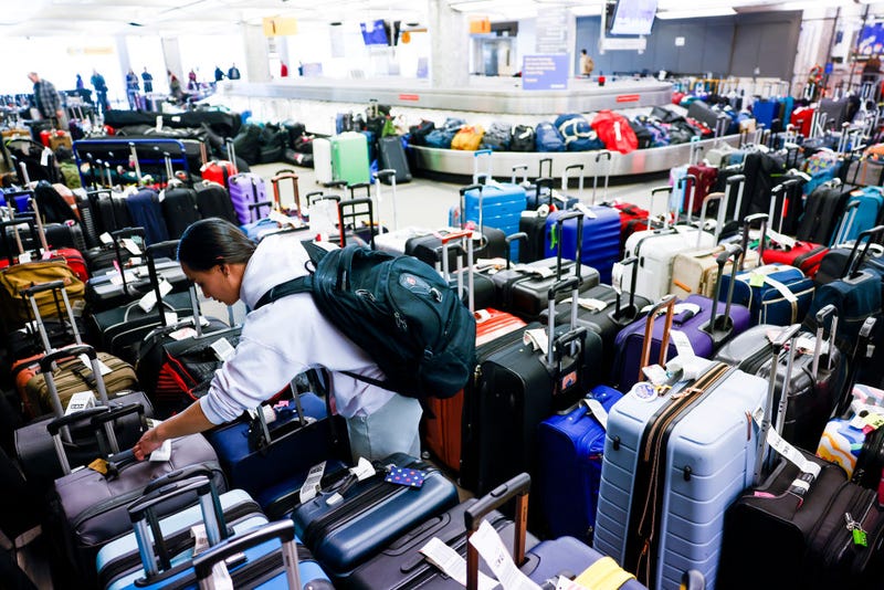 Pristine Floyde searches for a friend's suitcase in a baggage holding area for Southwest Airlines at Denver International Airport on December 28, 2022 in Denver, Colorado. More than 15,000 flights have been canceled by airlines since winter weather began impacting air travel on December 22. (Photo by Michael Ciaglo/Getty Images)