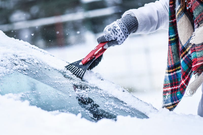 Scraping snow and ice from windshield
