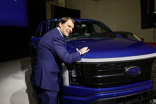 Ford CEO Jim Farley pats a Ford F-150 Lightning truck